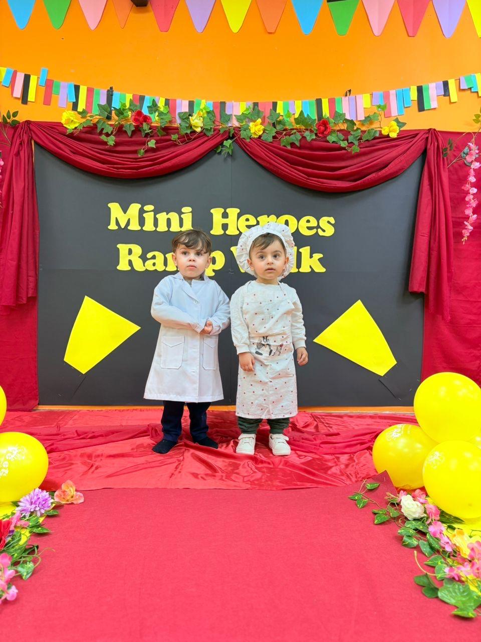 Two toddlers dressed as a scientist and a chef on the Mini Heroes stage