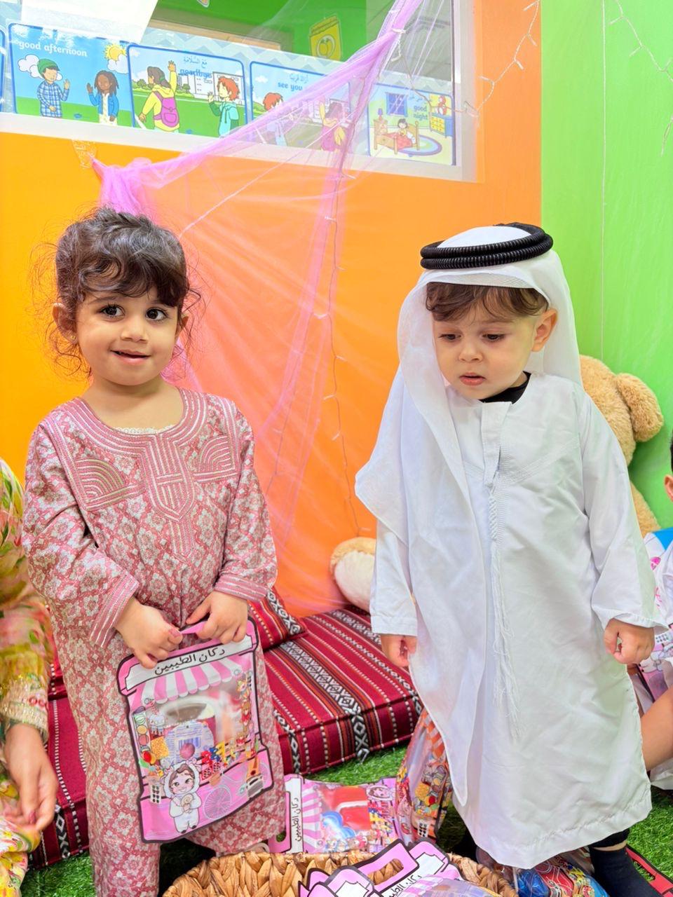 Two children in traditional Emirati dress celebrating UAE National Day